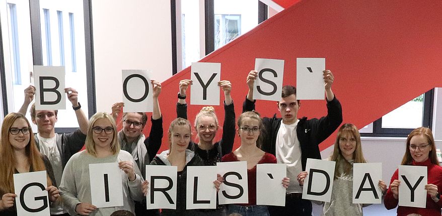 Afu dem Foto im Foyer der Kreisverwaltung in Haldensleben sieht man Mädchen und Jungen, die Blätter in den Händen haben, die die Worte Girls-Day und Boys-Day ergeben. Das ist ein Archivfoto aus 2022. Aktueller Bezug. Zukunftstag für 15 Mädchen und 15 Jungen am 28. April 2022 beim Landkreis Börde.