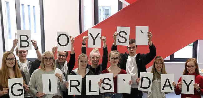 Afu dem Foto im Foyer der Kreisverwaltung in Haldensleben sieht man Mädchen und Jungen, die Blätter in den Händen haben, die die Worte Girls-Day und Boys-Day ergeben. Das ist ein Archivfoto aus 2022. Aktueller Bezug. Zukunftstag für 15 Mädchen und 15 Jungen am 28. April 2022 beim Landkreis Börde.