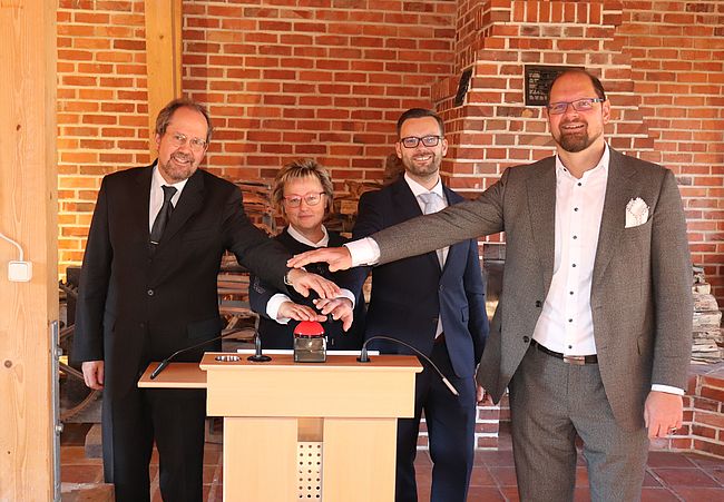 Das Foto zeigt Landrat Martin Stichnoth, Ludwig Strötges, Denkmalleiterin Marion Nier und Michael Tretschok im Kaminzimmer des Technischen Denkmals Ziegelei in Hundisburg beim "symbolischen Knopfdruck".