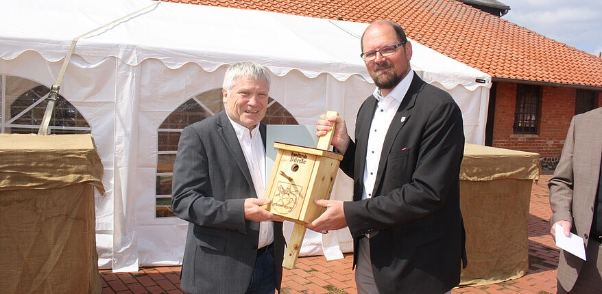 Foto Wohnungsbaugenossenschaft "Roland" Haldensleben / auch Landrat Martin Stichnoth wünscht dem künftigen Ruheständler Wolfgang Kaiser alles Gute. Stichnoth überreicht Kaiser ein "Vogelhaus".