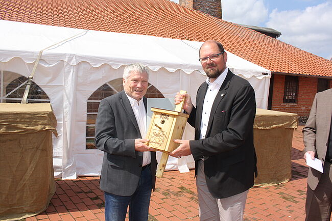 Foto Wohnungsbaugenossenschaft "Roland" Haldensleben / auch Landrat Martin Stichnoth wünscht dem künftigen Ruheständler Wolfgang Kaiser alles Gute. Stichnoth überreicht Kaiser ein "Vogelhaus".