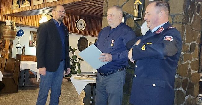 Das Foto zeigt Landrat Martin Stichnoth und Kreisbrandmeister Matthias Schumann. Beide zeichnen Kreisbrandmeister d. D. Horst Nitzer mit dem „Brand- und Katastrophenschutz Ehrenzeichen des Landkreises Börde“ aus. 