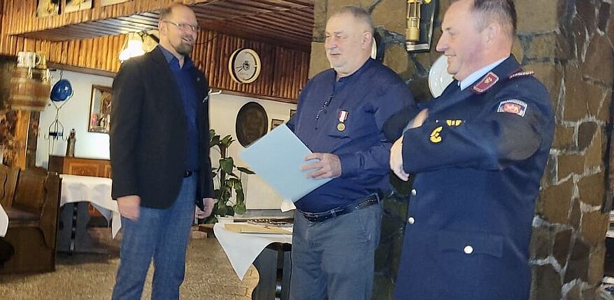Das Foto zeigt Landrat Martin Stichnoth und Kreisbrandmeister Matthias Schumann. Beide zeichnen Kreisbrandmeister d. D. Horst Nitzer mit dem „Brand- und Katastrophenschutz Ehrenzeichen des Landkreises Börde“ aus. 