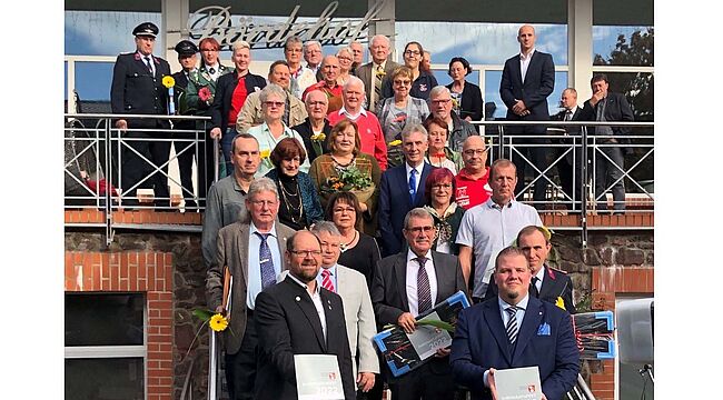 Landkreis Börde / ein Erinnerungsfoto vom ersten Ehrenamtsfest der Gemeinde Barleben in Ebendorf. Der Landrat, Bürgermeister Frank Nase und die Ausgezeichneten nehmen Aufstellung auf der Treppe vor dem Haupteingang.