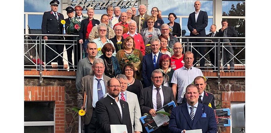 Landkreis Börde / ein Erinnerungsfoto vom ersten Ehrenamtsfest der Gemeinde Barleben in Ebendorf. Der Landrat, Bürgermeister Frank Nase und die Ausgezeichneten nehmen Aufstellung auf der Treppe vor dem Haupteingang.