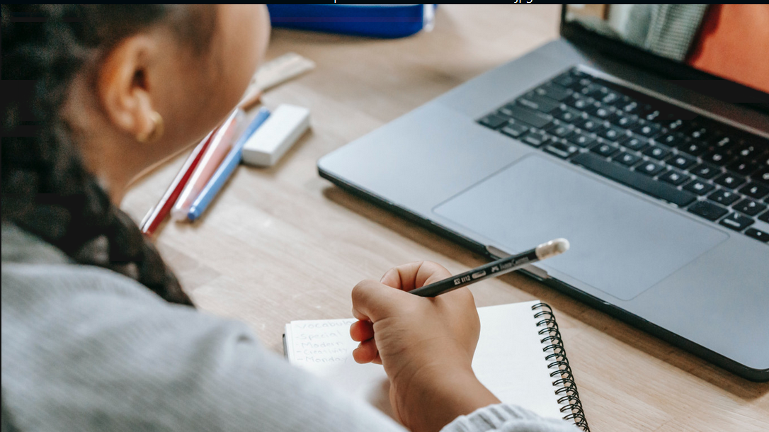The photo - Pexels / Katerina Holmes titled digital literacy - a key to teaching from home / shows A schoolgirl with a pen in her hand