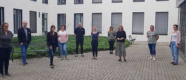 Das Foto im Innenhof des Verwaltungsgebäudes des Landkreises Börde in Haldensleben zeigt unter Einhaltung der Abstandsregel 10 Personen, die im Netzwerk Familie mitarbeiten. Unter anderem Katja Klommhaus, Gleichstellungsbeauftragte des Landkreises Börde.