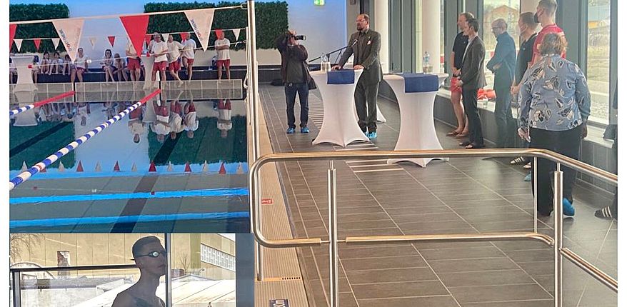 Das Foto zeigt den Innenraum der Schwimmhalle. Im vorgergrund steht Olympiasieger Florian Wellbrock / im Hintergrund spricht Landrat Martin Stichnoth zu den Gästen. 