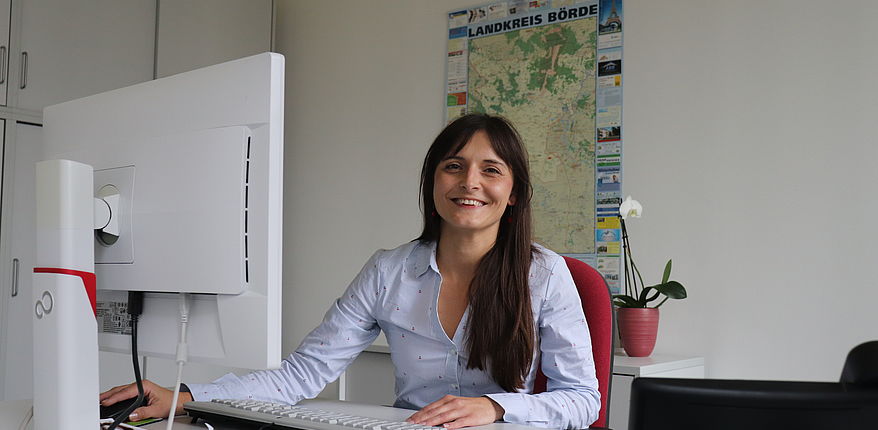 Gleichstellungsbeauftragte Katja Klommhaus sitzt in ihrem Büro am Schreibtsich. Sie sagt im Kontext zum Internationalen Frauentag 2022 "Weil wir es uns wert sind!"