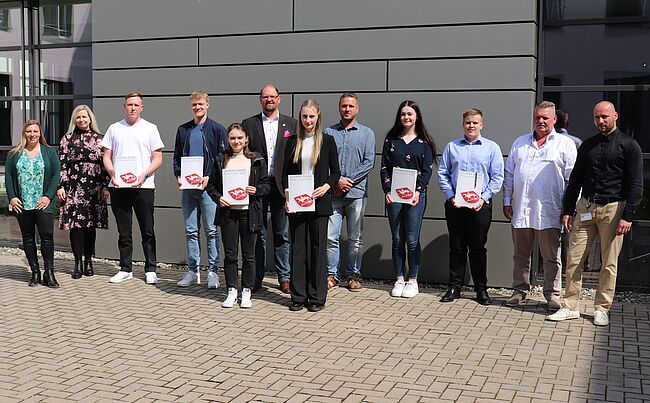 Foto Uwe Baumgart / Aufstellung zum Erinnerungsfoto - von links: Manuela Brasch und Julia Herzberg-Ebeling / Personalamt, Tim Becker, Bennett Herrmanns, Anna Kostohryz, Landrat Martin Stichnoth, Colien Sulfrian, Michael Rusche / Ausbilder Straßenwärter, Clara Daul, Maurice Elling, Frank Holzheuer / Straßenmeister und Alexander Keyl / Leiter Rettungswache.