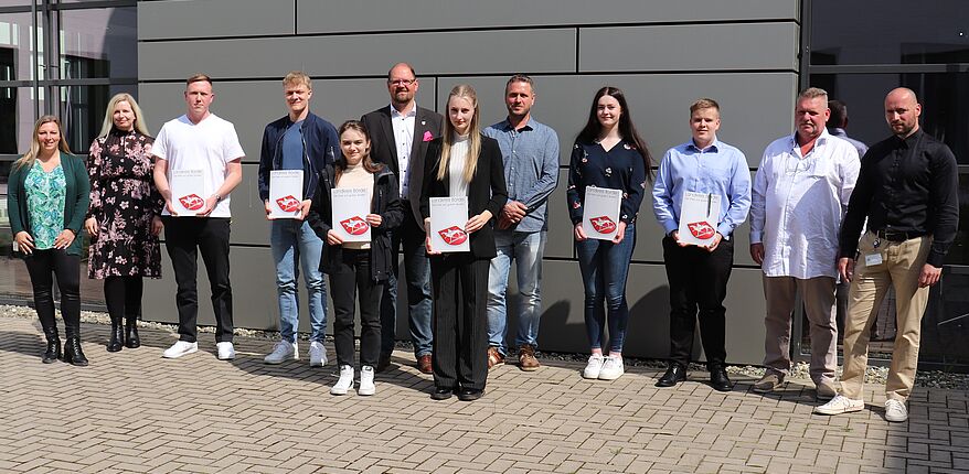Foto Uwe Baumgart / Aufstellung zum Erinnerungsfoto - von links: Manuela Brasch und Julia Herzberg-Ebeling / Personalamt, Tim Becker, Bennett Herrmanns, Anna Kostohryz, Landrat Martin Stichnoth, Colien Sulfrian, Michael Rusche / Ausbilder Straßenwärter, Clara Daul, Maurice Elling, Frank Holzheuer / Straßenmeister und Alexander Keyl / Leiter Rettungswache.