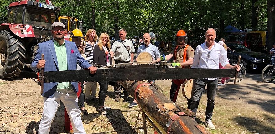 Landkreis Börde / Es gab eine Reihe von interessanten Informationen. Hier zum traditionellen Sägevorgang mit einer Schrotsäge. Im Vordergrund Landrat Martin Stichnoth und Kreistagsmitglied Wolfgang Zahn.