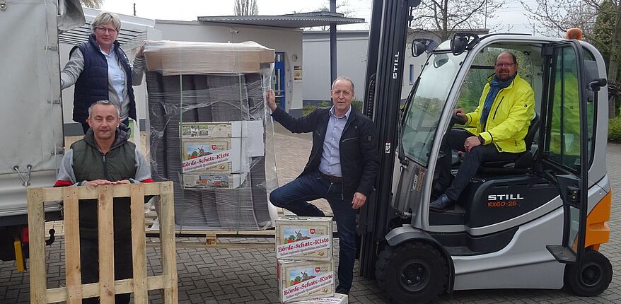 Foto Agrarmarketinggesellschaft Sachsen-Anhalt / die Rohlinge für die "Börde Schatz Kiste" werden in Seehausen (Börde) unter Mithilfe von Landrat Martin Stichnoth entladen. Stichnoth sitzt auf einem Gabelstapler.