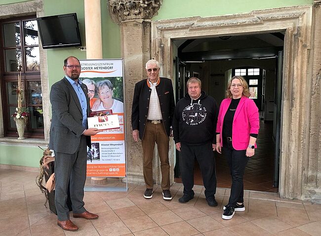 Foto Landkreis Börde / Landrat Martin Stichnoth gratuliert Betreibern des Betreuungszentrum zum Jubiläum. Mit einer Schachtel "Merci" in der Hand sagt der Landrat danke. 