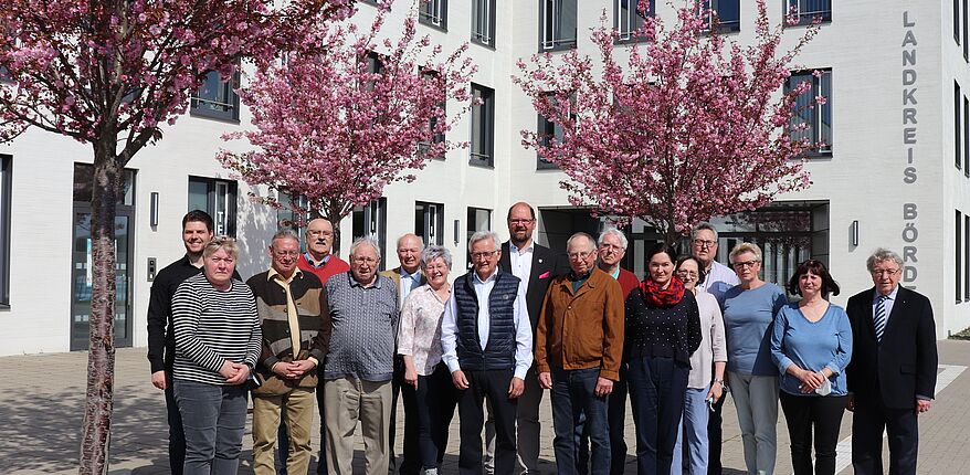 Foto Uwe Baumgart / Aufstellung vor dem Verwaltungsgebäude des Landkreises Börde in Haldensleben zum Erinnerungsfoto. In der Mitte, links neben Landrat Martin Stichnoth, steht Ulrich Körber, Vorsitzender des Seniorenrates. Links außen: Dominik Scholz ist in der Verwaltung als Geschäftsstelle für den Kreisseniorenrat verantwortlich  