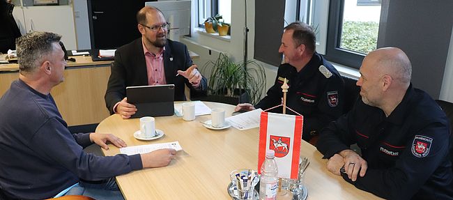 Das Foto zeigt den Beratungstisch des Landrates in Haldensleben. Ralf Lange (links) Dirk Bischoff (rechts) und Kreisbrandmeister Matthias Schumann (neben Bischoff) informieren Landrat Martin Stichnoth über Hilfeleistungen der Feuerwehren infolge des Sturmtiefs "Ylenia".