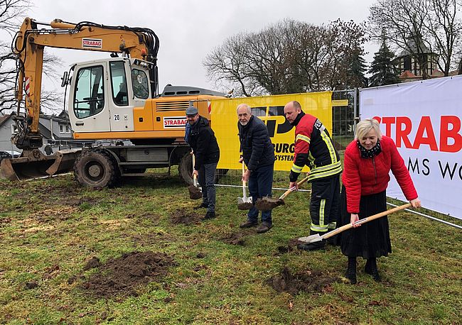Das Foto zeigt 4 Personen mit einen Spaten in der Hand. Hintergrund, sie vollziehen den ersten Spatenstich für den Neubau des Feuerwehrgerätehauses in Farsleben. Im Bild unter anderem Wolmirstedt´s Bürgermeisterin Marlies Cassuhn und Landrat Martin Stichnoth. 