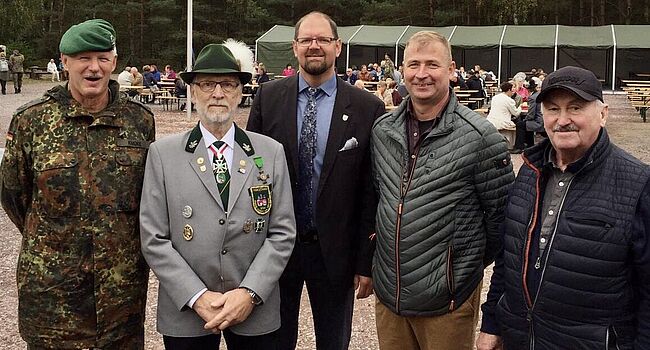 Das Foto zeigt im Vordergrund 5 Personen, darunter Landrat Martin Stichnoth, Kreisschützenmeister Hartmut Neumann und Oberst Michael Knoke, Leiter des Gefechtsübungszentrums des Heeres Letzlingen. Im Hintergrund ist ein Festzelt zu sehen.