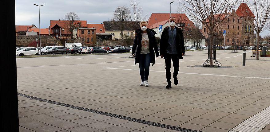 Foto Uwe Baumgart / zunächst bis zum 22. April 2022 bleibt das Tragen einer medizinischen "Mund-Nasen-Bedeckung" für Besucher der Verwaltungsgebäude des Landkreises Börde verpflichtend. Auf dem Foto kommen 2 Besucher mit FFP2-Maske in das Haldensleber Verwaltungsgebäunde. Im Hintergrund sieht man die Stadt mit Kirchturm und Stendaler Torturm. 