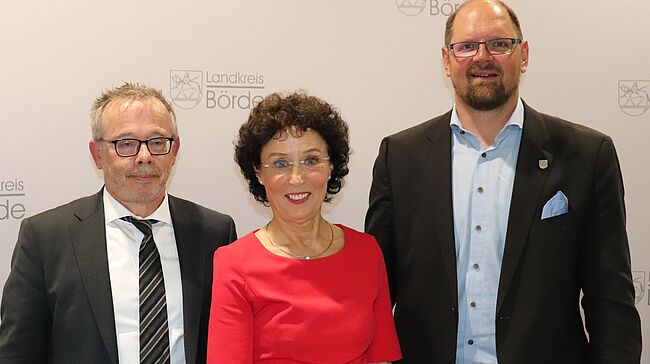 Foto Uwe Baumgart / Landrat Martin Stichnoth und Beigeordneter Peter Weiß (Landkreistag Sachsen-Anhalt) ehren Petra Naumann mit der silbernen Ehrennadel des Landkreistages von Sachsen-Anhalt. Die beiden Herren nehmen Petra Naumann in die Mitte.