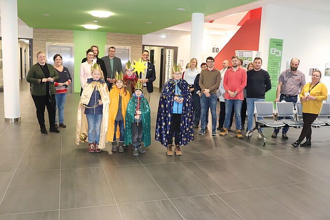 Foto Uwe Baumgart / die Sternsinger segnen das Verwaltungsgebäude des Landkreises Börde. Beschäftigte der Verwaltung sind gekommen, um zu spenden.