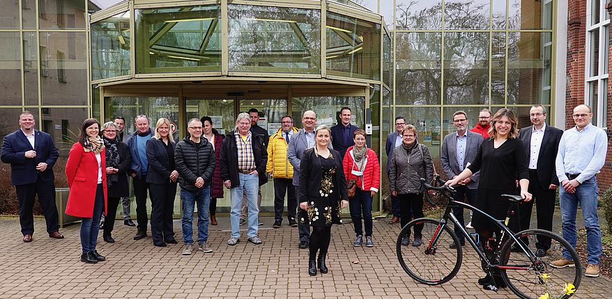 Auch für dokumentarische Zwecke. Aufstellung zum Gruppenfoto vor dem Verwaltungsgebäude des Landkreises Börde in Oschersleben. Mit dem Rad in den Händen Radverkehrskoordination Marlen Lekschas, Bildmitte (vorn) Annett Dippe, Leiterin Kreisplanung.